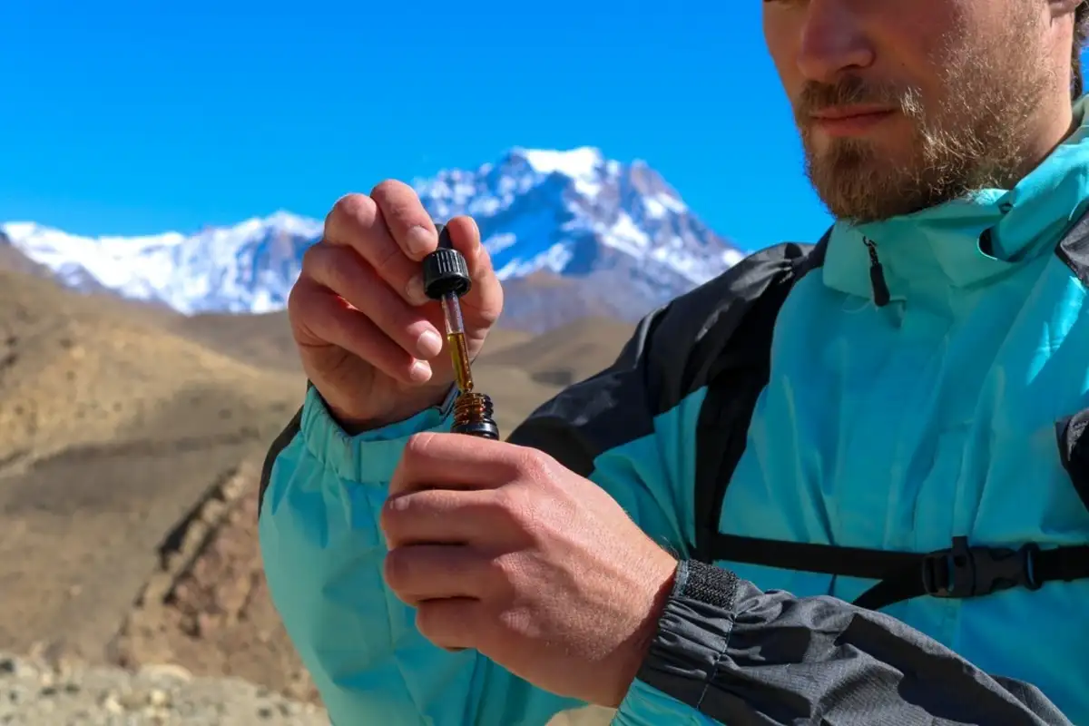 Man in a blue jacket holding cannabis