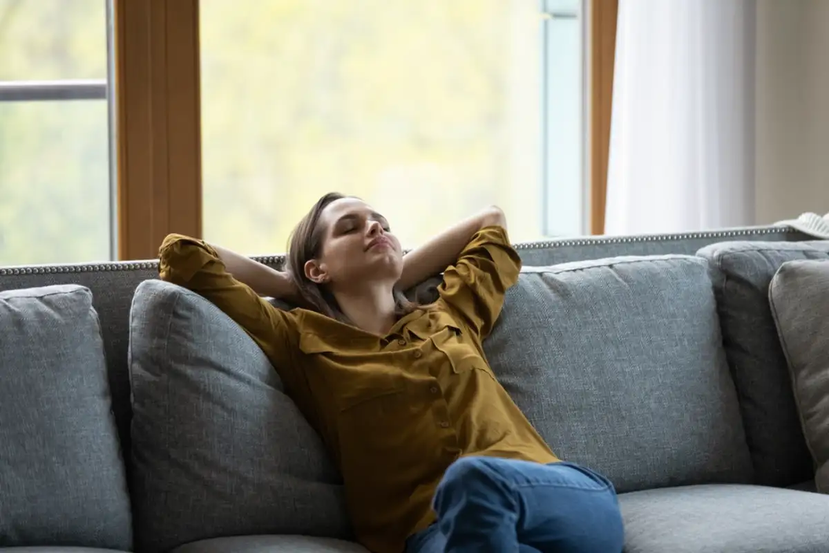 Sleepy young woman relaxing on comfortable sofa