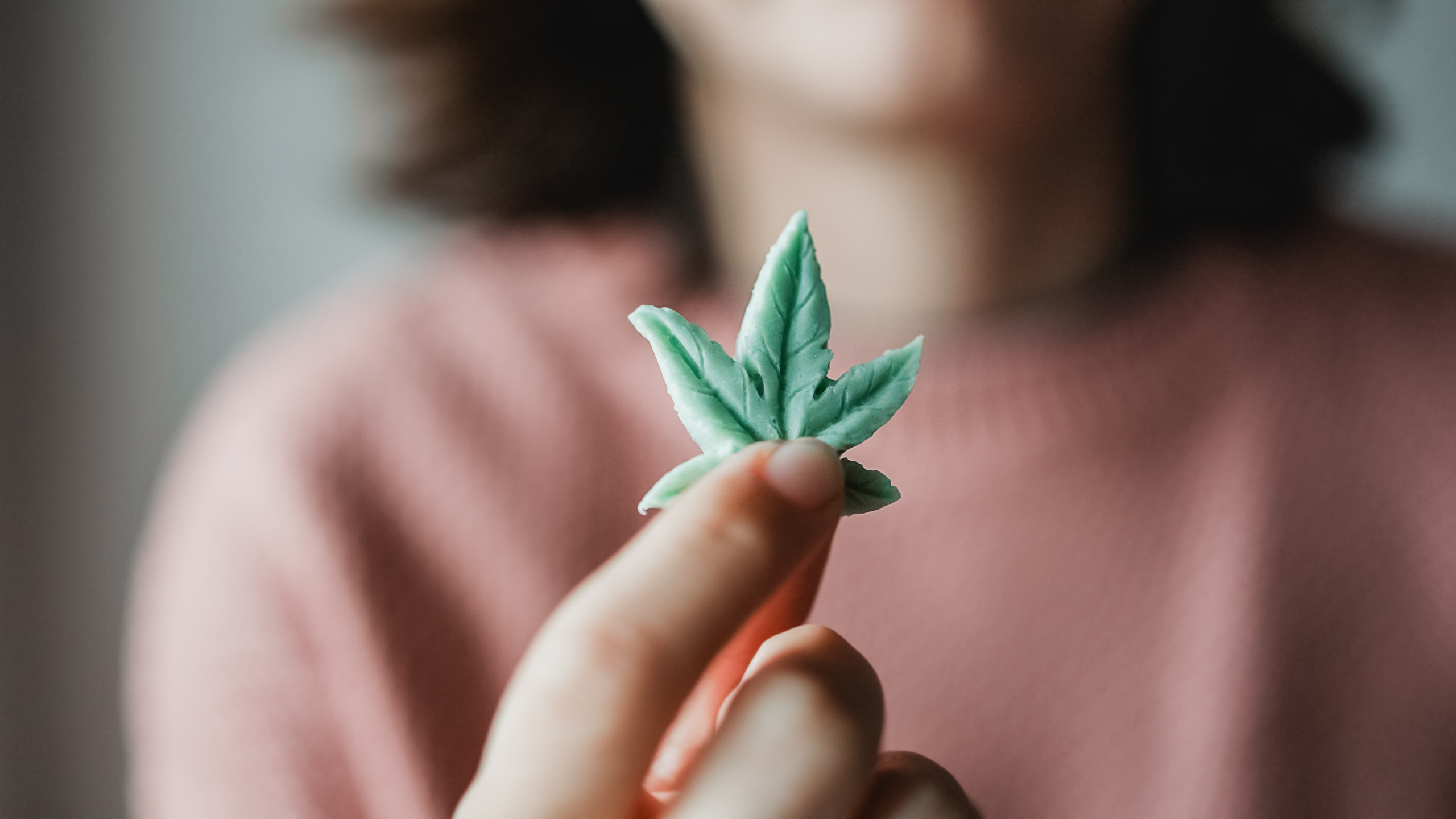 cbd candy woman holding edible cannabis leaf 